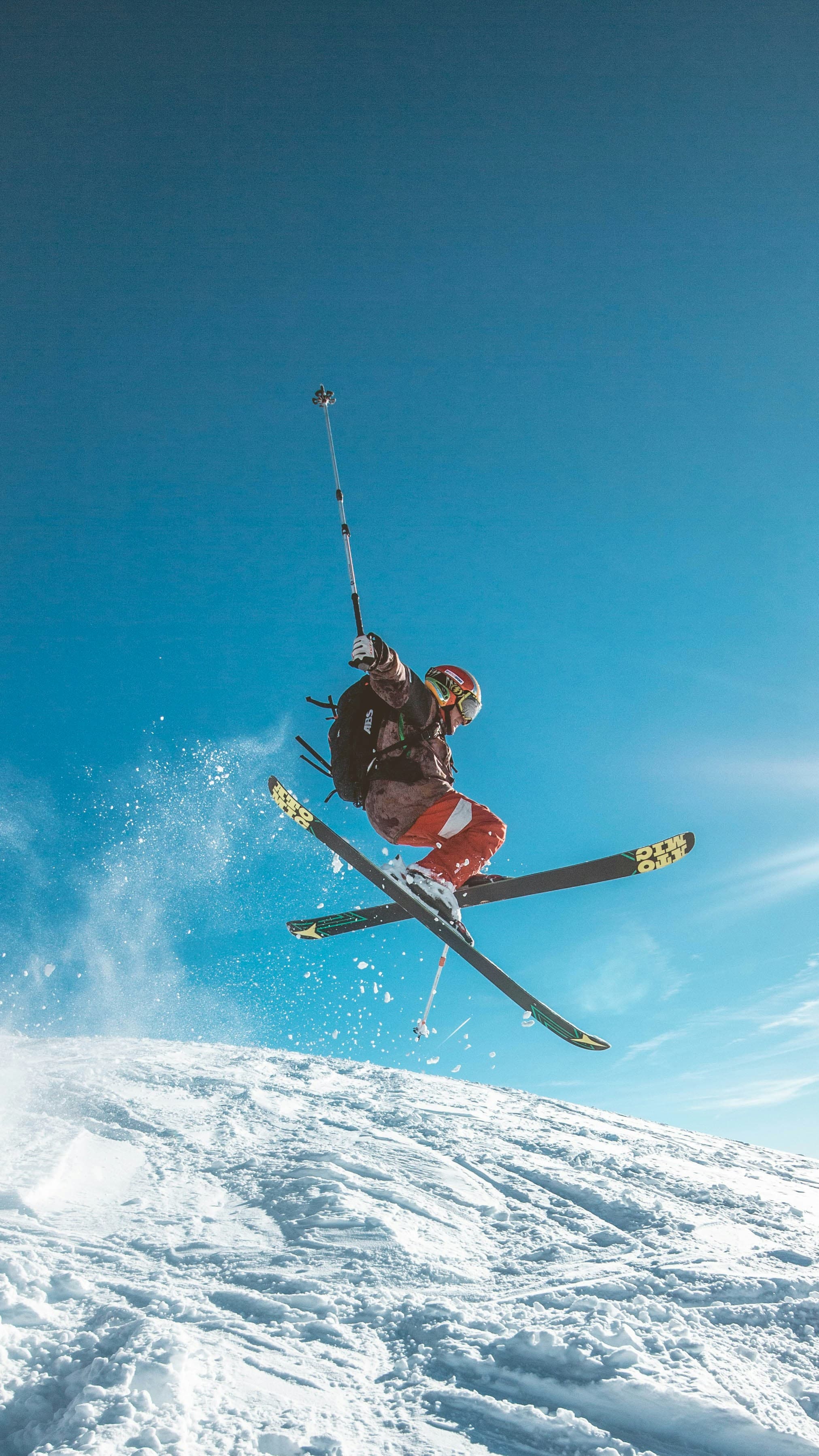 Esquiador en pleno salto sobre nieve, acción deportiva de alto rendimiento.